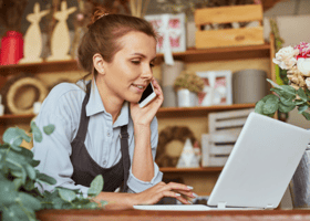 Pequeña empresaria en el teléfono y computador